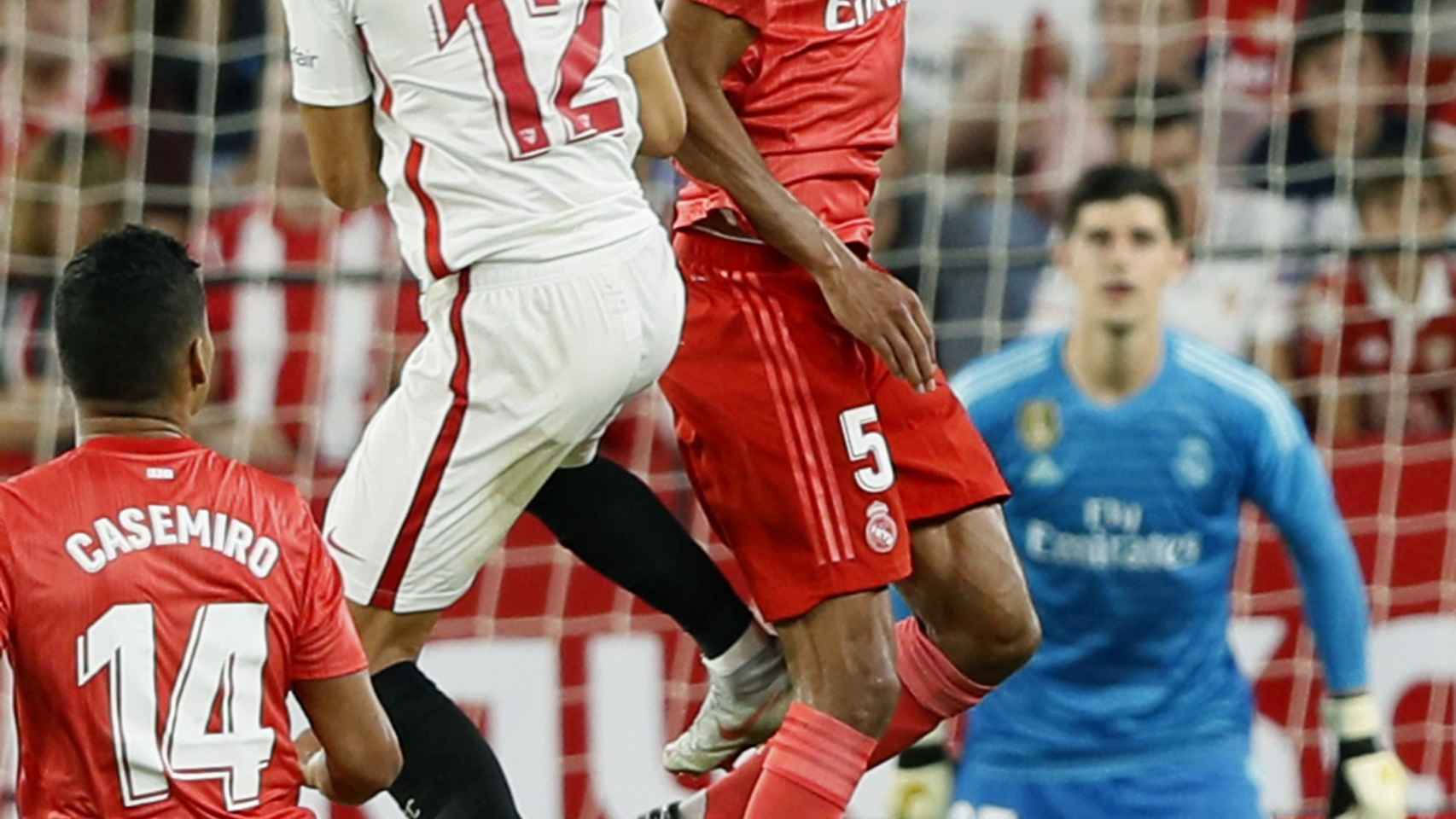Raphael Varane despeja el balón ante el delantero portugués del Sevilla, André Silva
