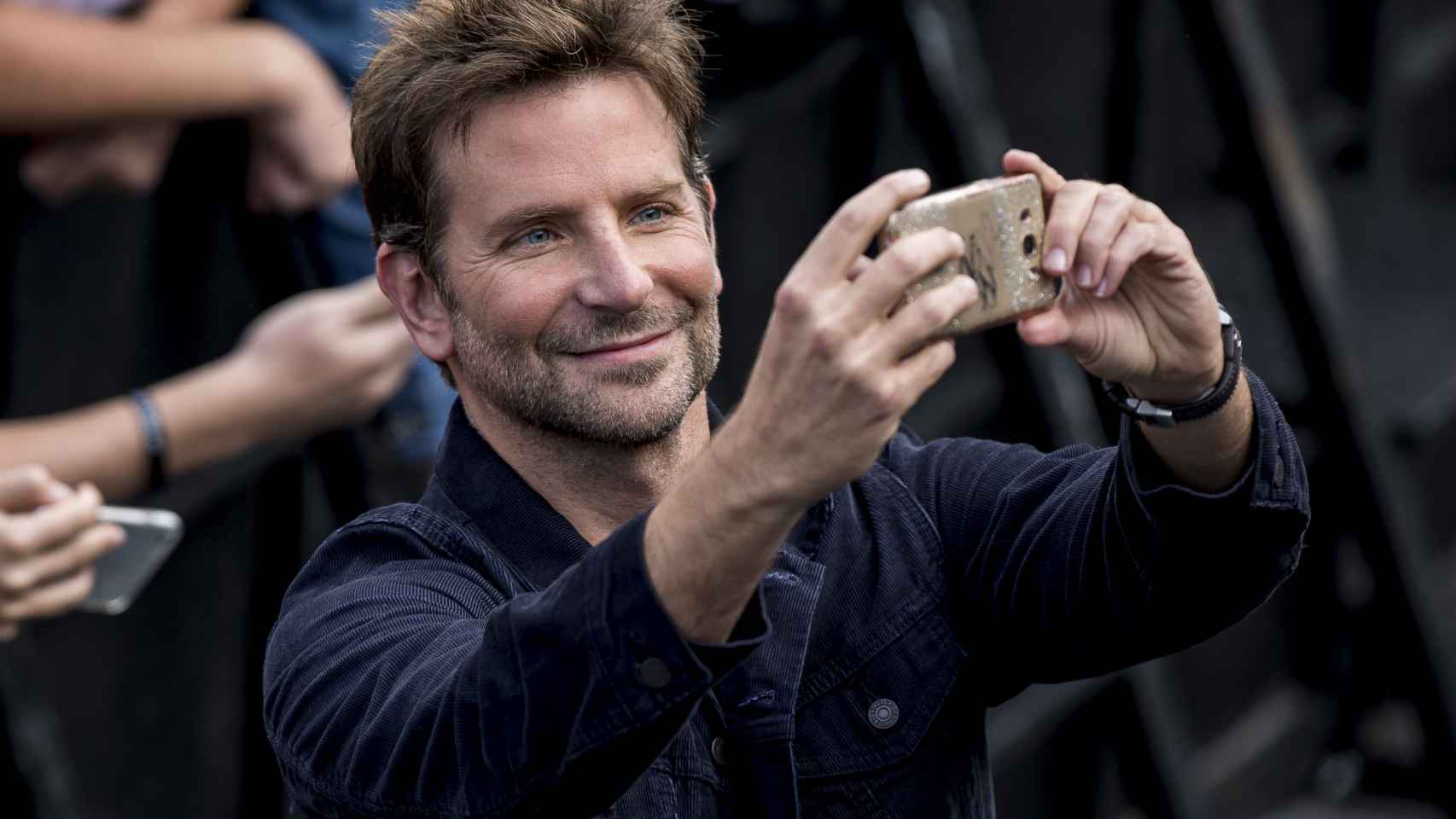 Bradley Cooper, con el móvil de una seguidora para hacerse un 'selfie'.
