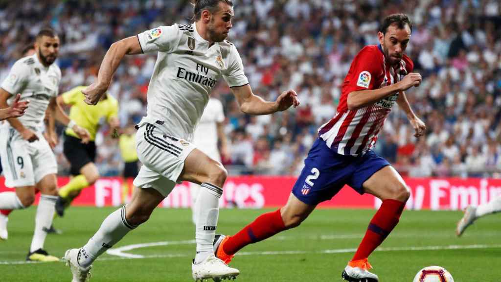 Bale disputa un balón con Godín