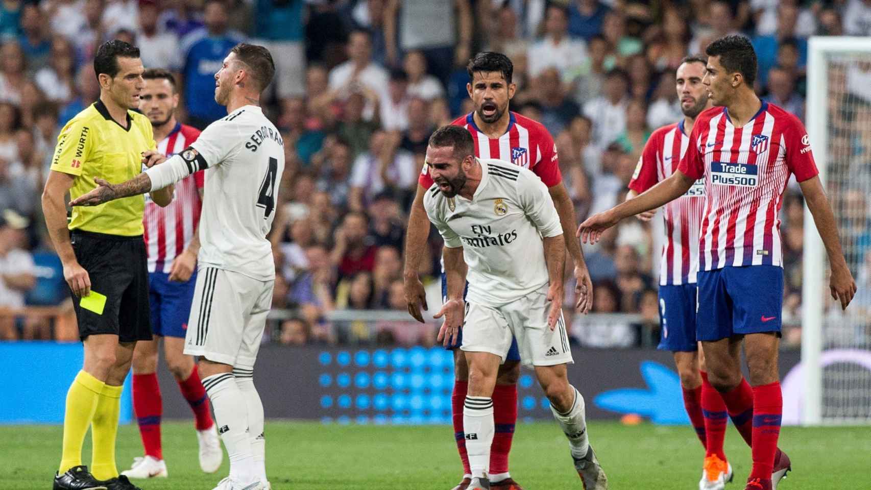 El defensa del Real Madrid, Sergio Ramos, protesta la tarjeta amarilla que el colegiado Martínez Munuera
