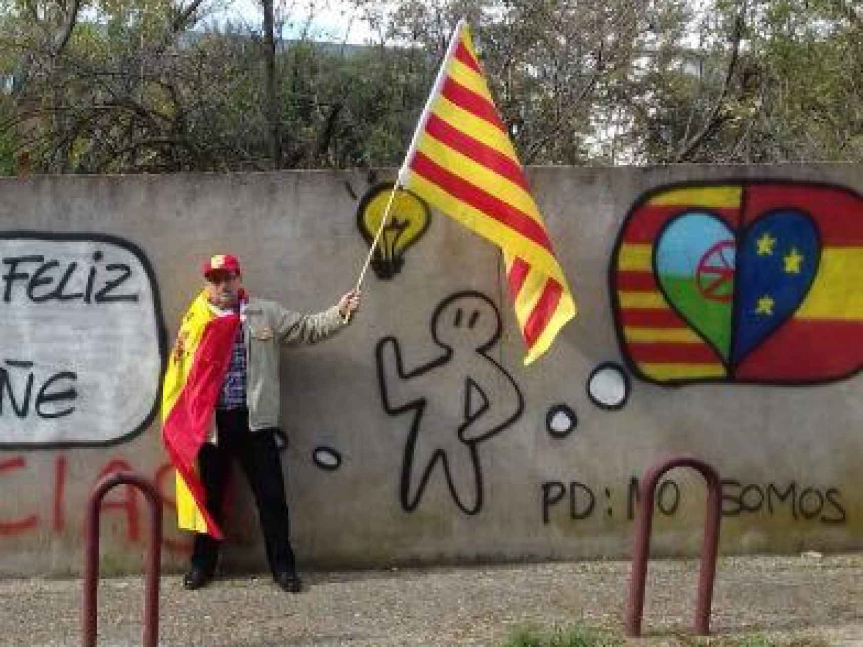 Un vecino posa con las banderas española, catalana, europea y gitana