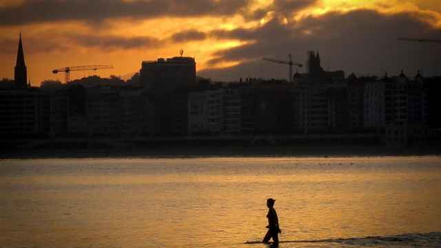 Una mujer se baña al amanecer en la playa de Ondarreta en San Sebastián.