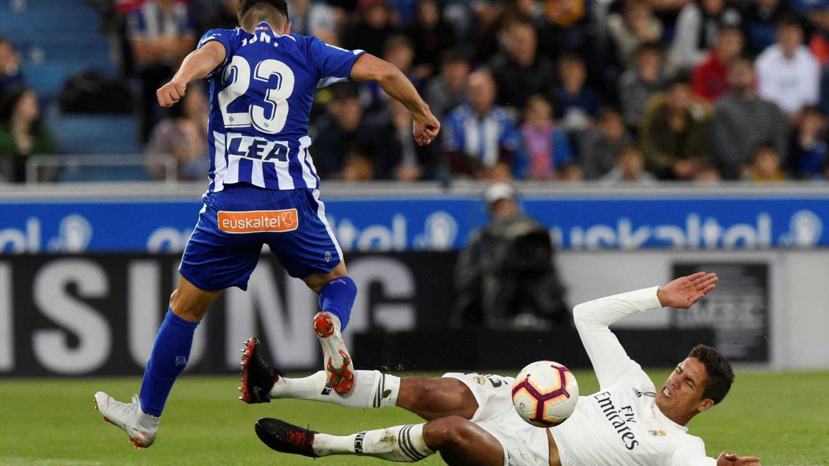 Varane pelea por un balón desde el suelo ante un jugador del Alavés