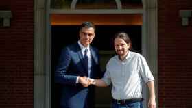 Pedro Sánchez y Pablo Iglesias se dan la mano a las puertas de la Moncloa.
