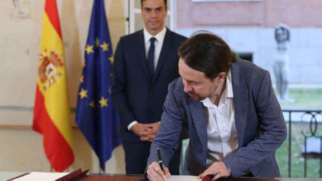 Iglesias firma el acuerdo con Sanchez en la Moncloa.