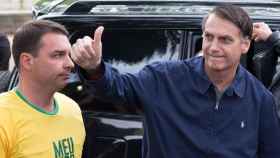 Jair Bolsonaro, junto a su hijo, saluda a los seguidores ante de votar en Río de Janeiro.
