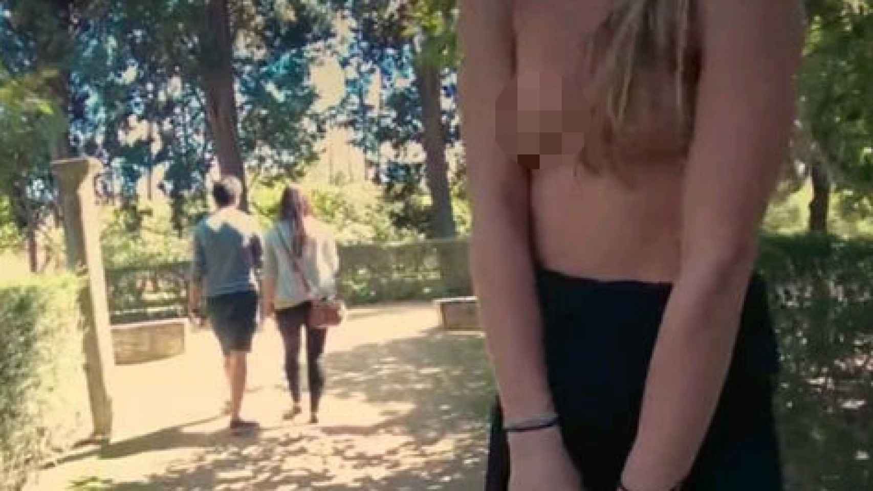 Fotograma de la película porno junto a un par de turistas de fondo.