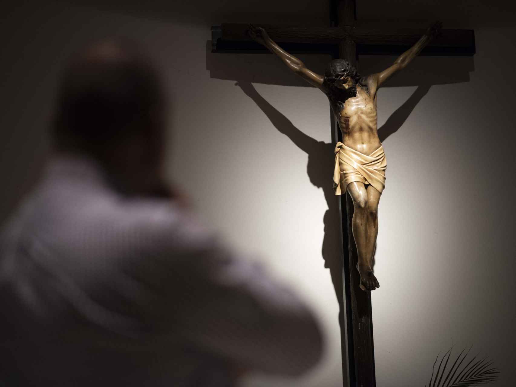 Un expresidiario condenado por maltrato de género reza ante la cruz de Jesús.