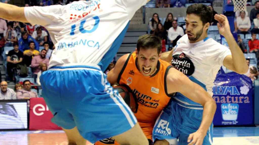 Sam Van Rossom juega la pelota entre Vladimir Brodzamsky y Pepe Pozas en el Monbus Obradoiro - Valencia Basket