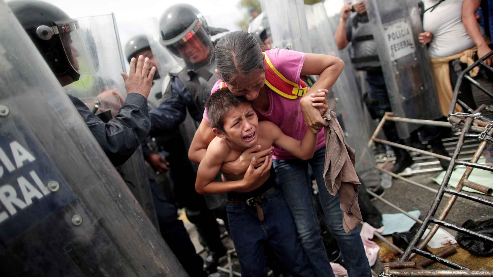 Una migrante hondureña protege a su hijo, después de cruzar la frontera de México.