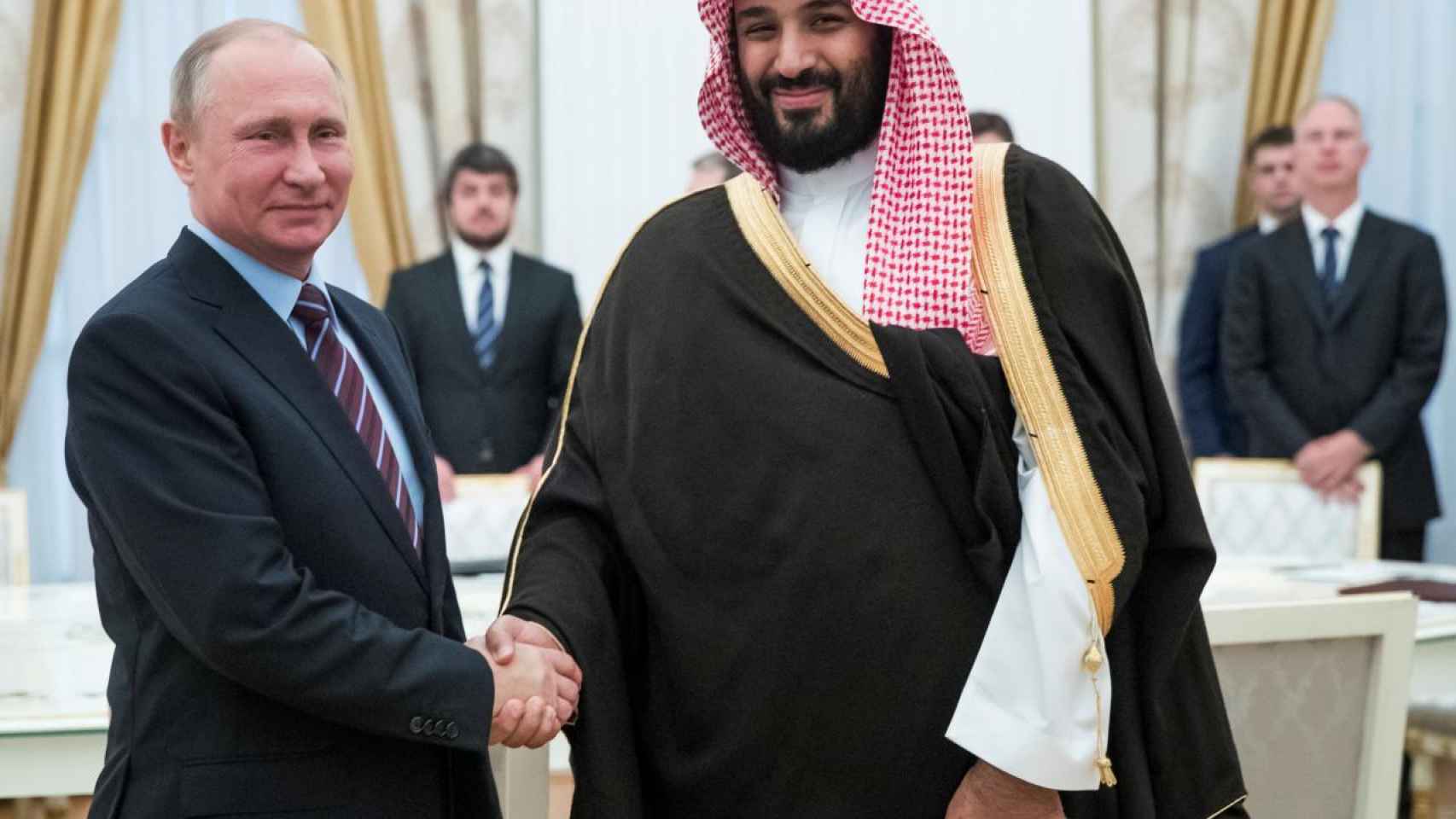 El presidente ruso Vladimir Putin le da la mano al  heredero saudí Mohammed bin Salman.