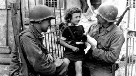 Dos soldados tratan de consolar a una niña herida durante la II Guerra Mundial.