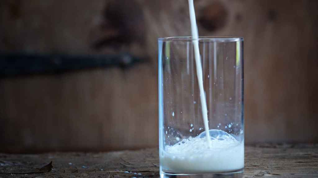 Un chorro de leche cayendo sobre un vaso.