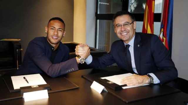 Neymar y el  presidente del F. C. Barcelona, Josep María Bertomeu, en la firma de su fichaje.