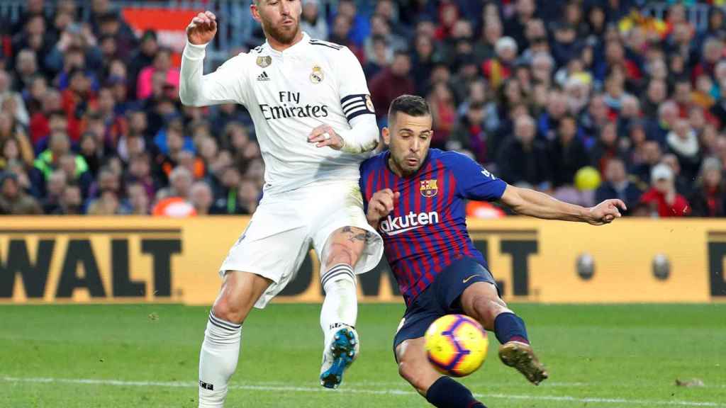Jordi Alba disputa un balón con Sergio Ramos.