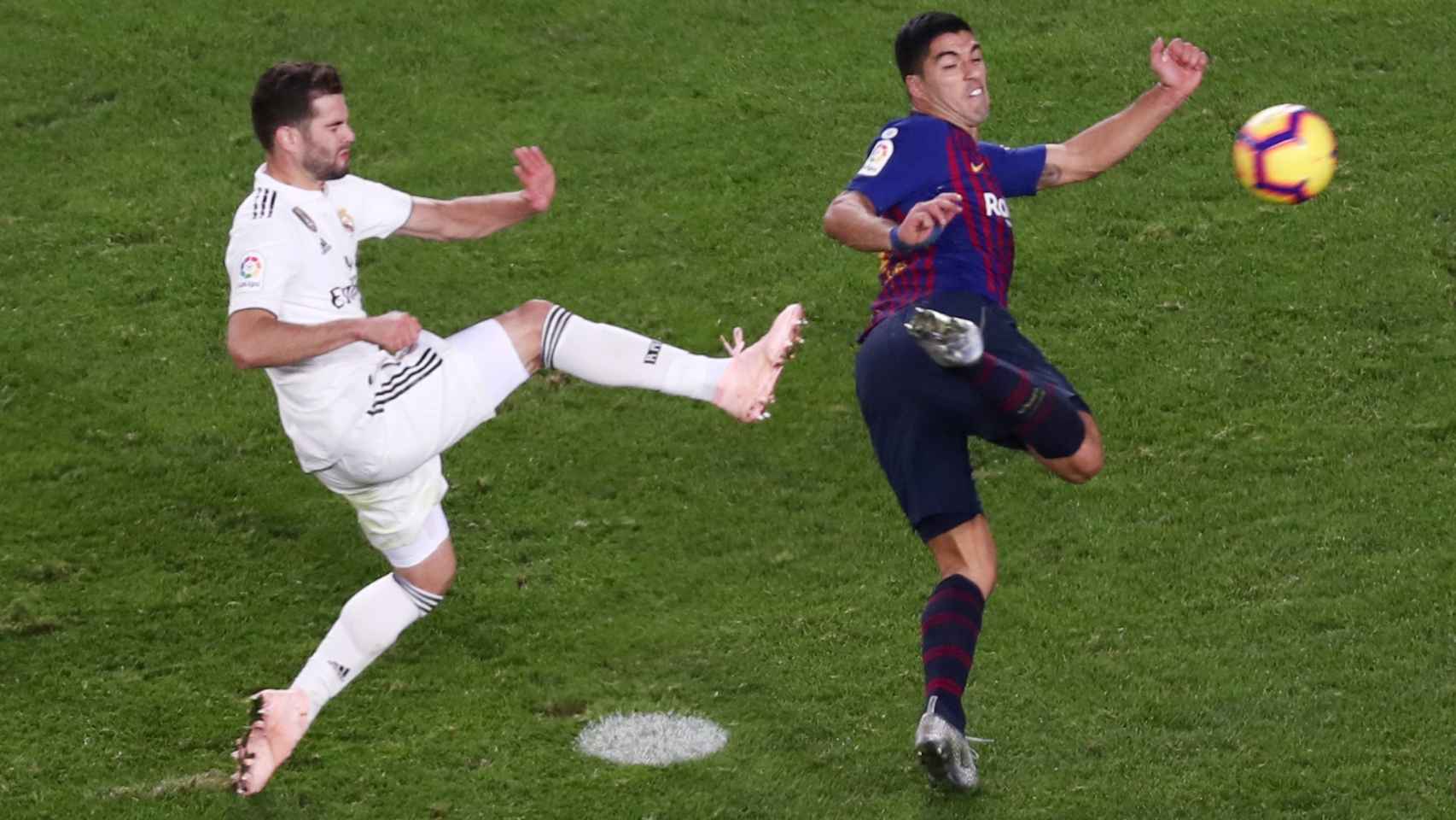 Luis Suárez remata un balón junto a Nacho.