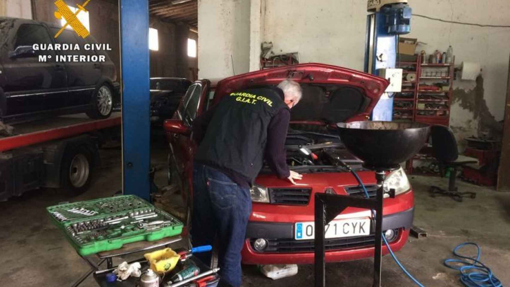 Un guardia civil inspecciona un coche durante una intervención en un taller