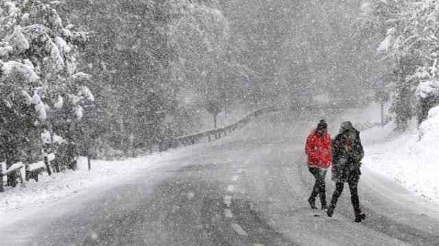 Dos personas caminan bajo una intensa nevada en Roncesvalles.