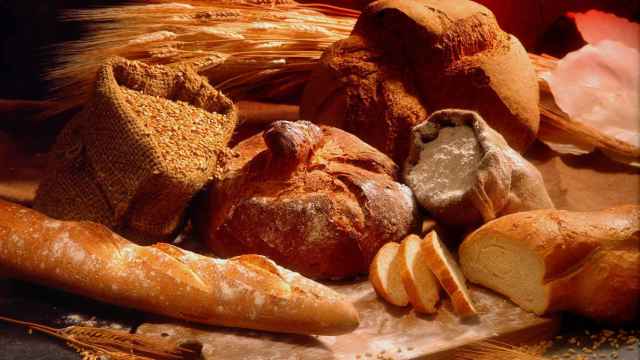 Varios tipos de pan en un mostrador con sus ingredientes alrededor