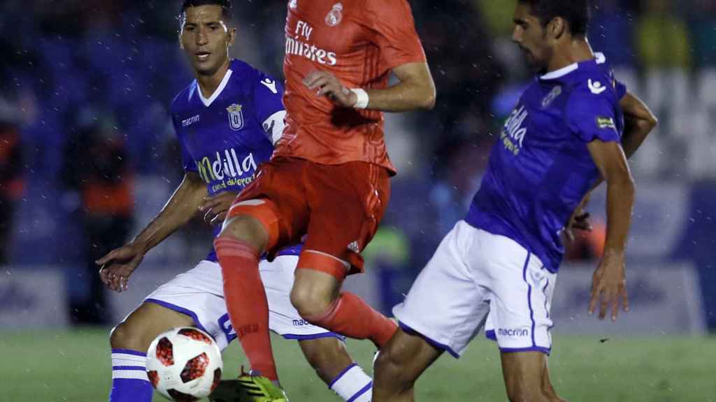 Karim Benzema, entre los jugadores del Melilla durante el partido