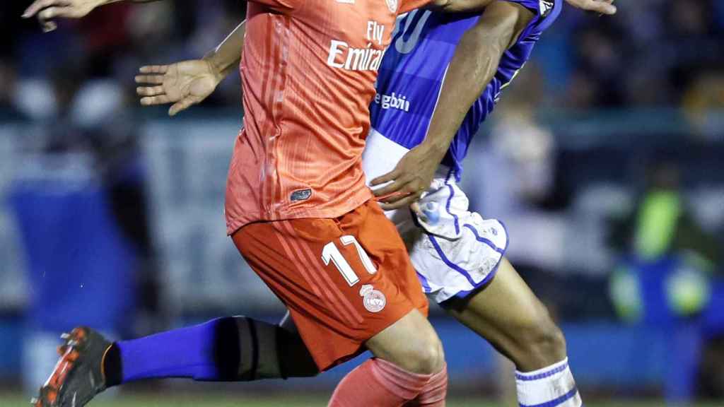 El centrocampista del Melilla Antonio Otegui pelea por un balón contra el jugador del Real Madrid Lucas Vázquez