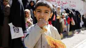 Menor yemení con comida proporcionada por ONG.