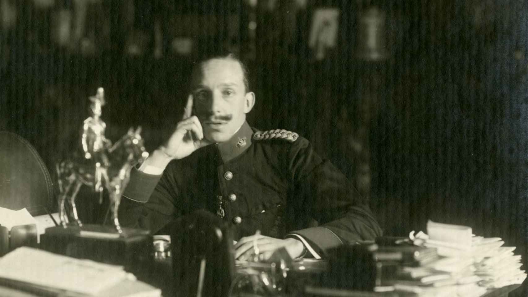 Retrato de Alfonso XIII sentado ante su mesa de despacho con el uniforme del Regimiento Inmemorial del Rey.