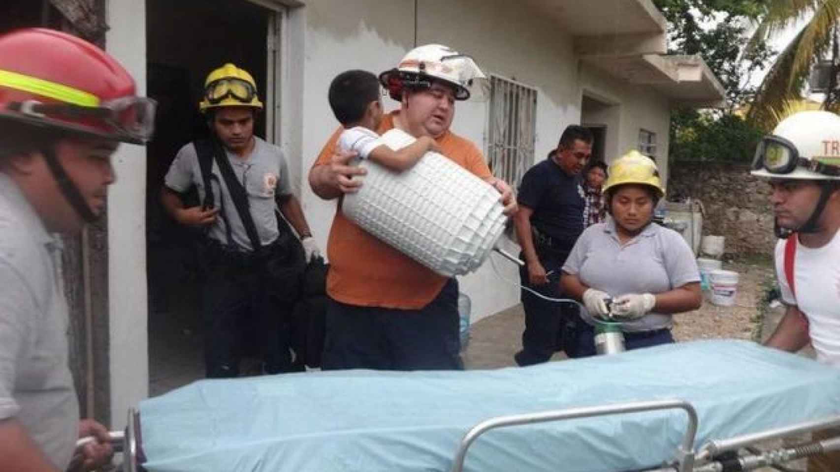 Los bomberos trasladando al niño para poder sacarlo del bombo