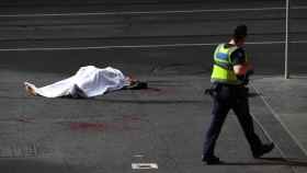 El cadáver de una víctima yace sobre el asfalto tras el ataque.