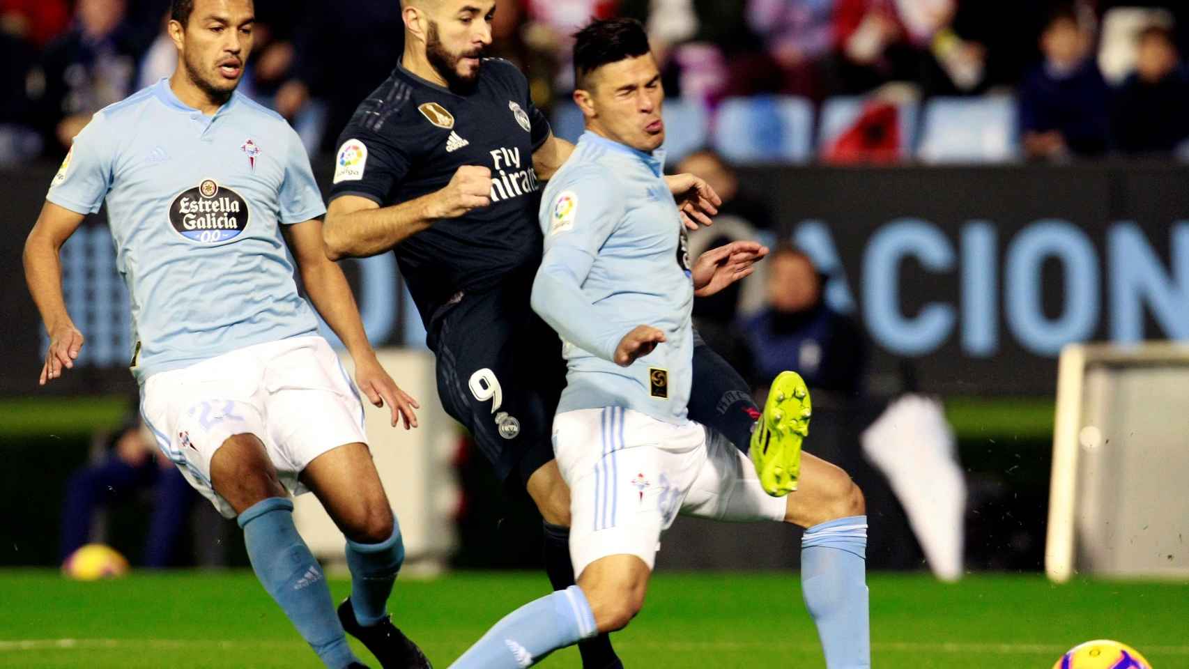 Karim Benzema golpea el balón ante los defensas argentinos del Celta Gustavo Cabral y Facundo Roncaglia