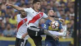 El jugador Dario Benedetto de Boca Juniros disputa la pelota con Exequiel Palacios de River Plate