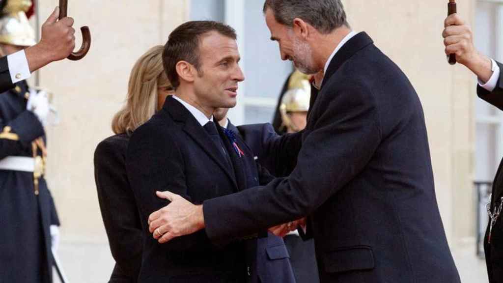 Felipe VI, solo, saluda a Emmanuel y Brigitte Macron a su llegada a París.