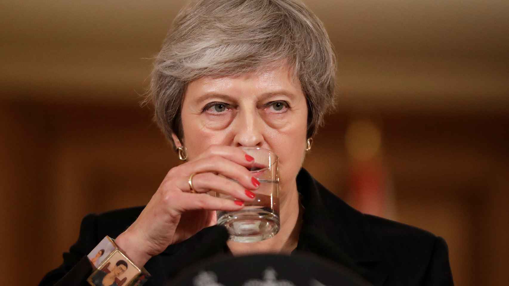 May da un trago durante su comparecencia este jueves en Downing Street.