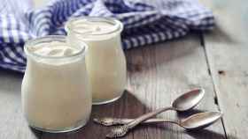 Un par de yogures de marca blanca con sus respectivas cucharillas.
