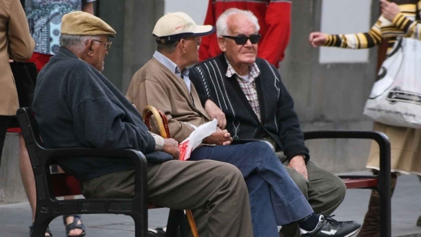Ancianos  sentados en un banco.