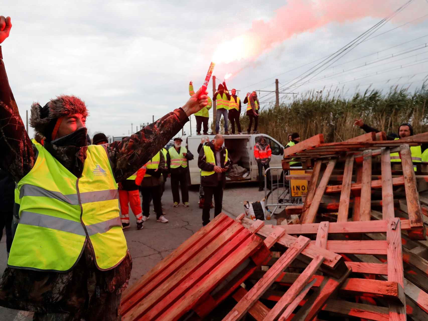 Manifestantes vestidos con chalecos amarillos bloquean el acceso a la refinería de Frontignan.