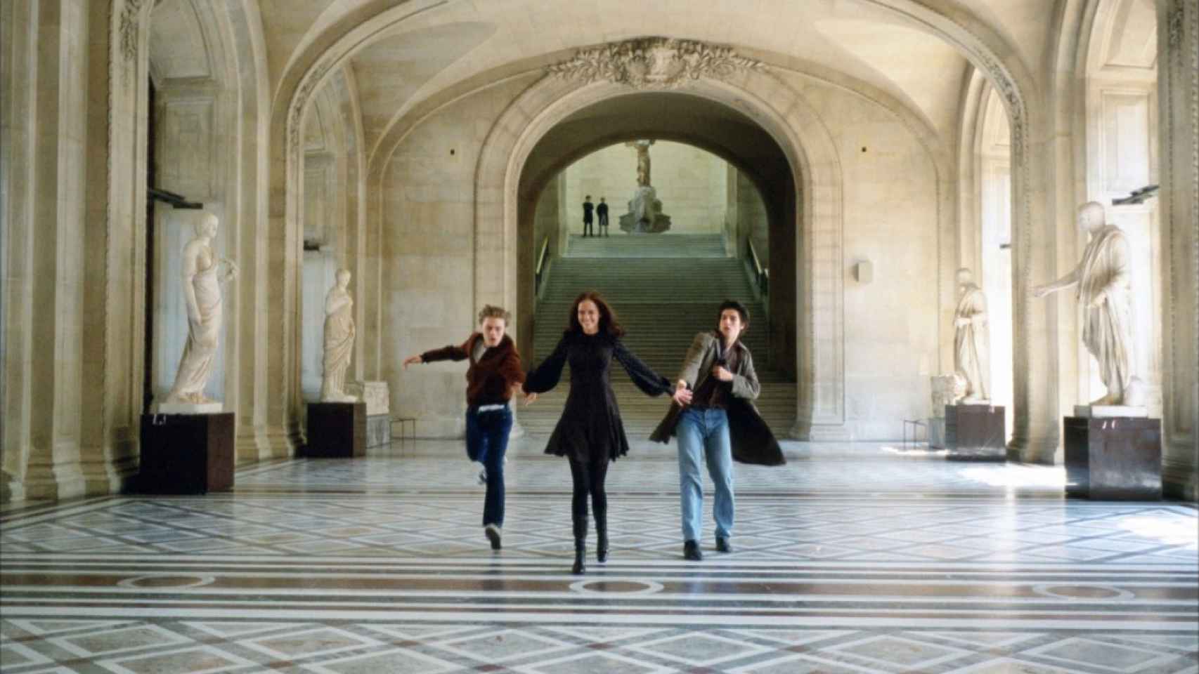 Los tres jóvenes corriendo por el Louvre.