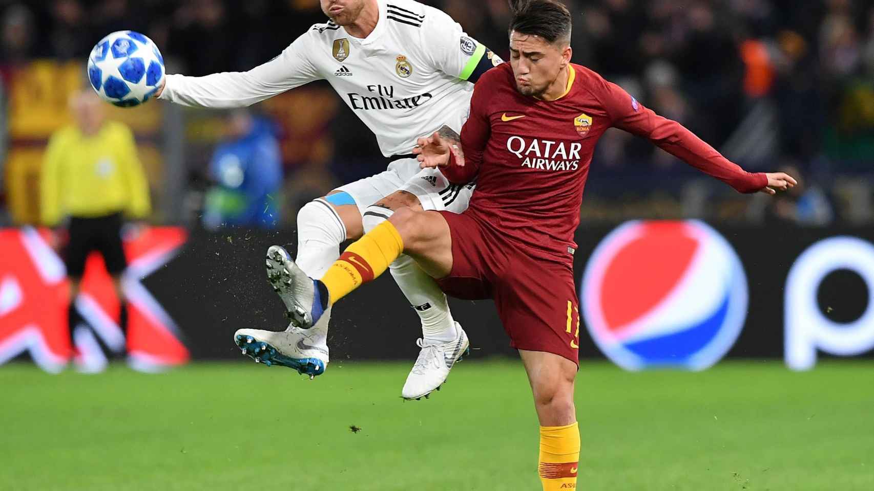 Cengiz Under de la Roma disputa un balón con Sergio Ramos