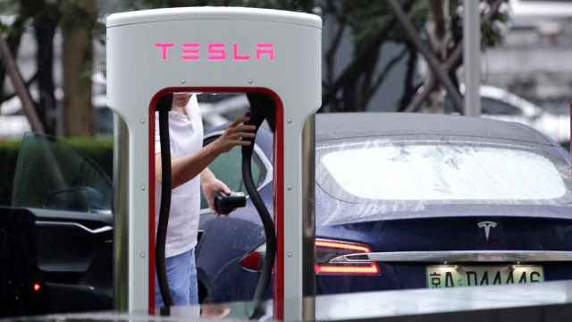 Un conductor de un Tesla cargando el vehículo.