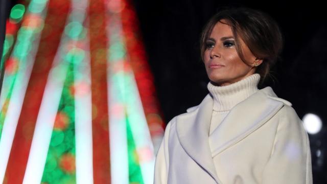 Melania Trump emocionada con el árbol de Navidad a sus espaldas.