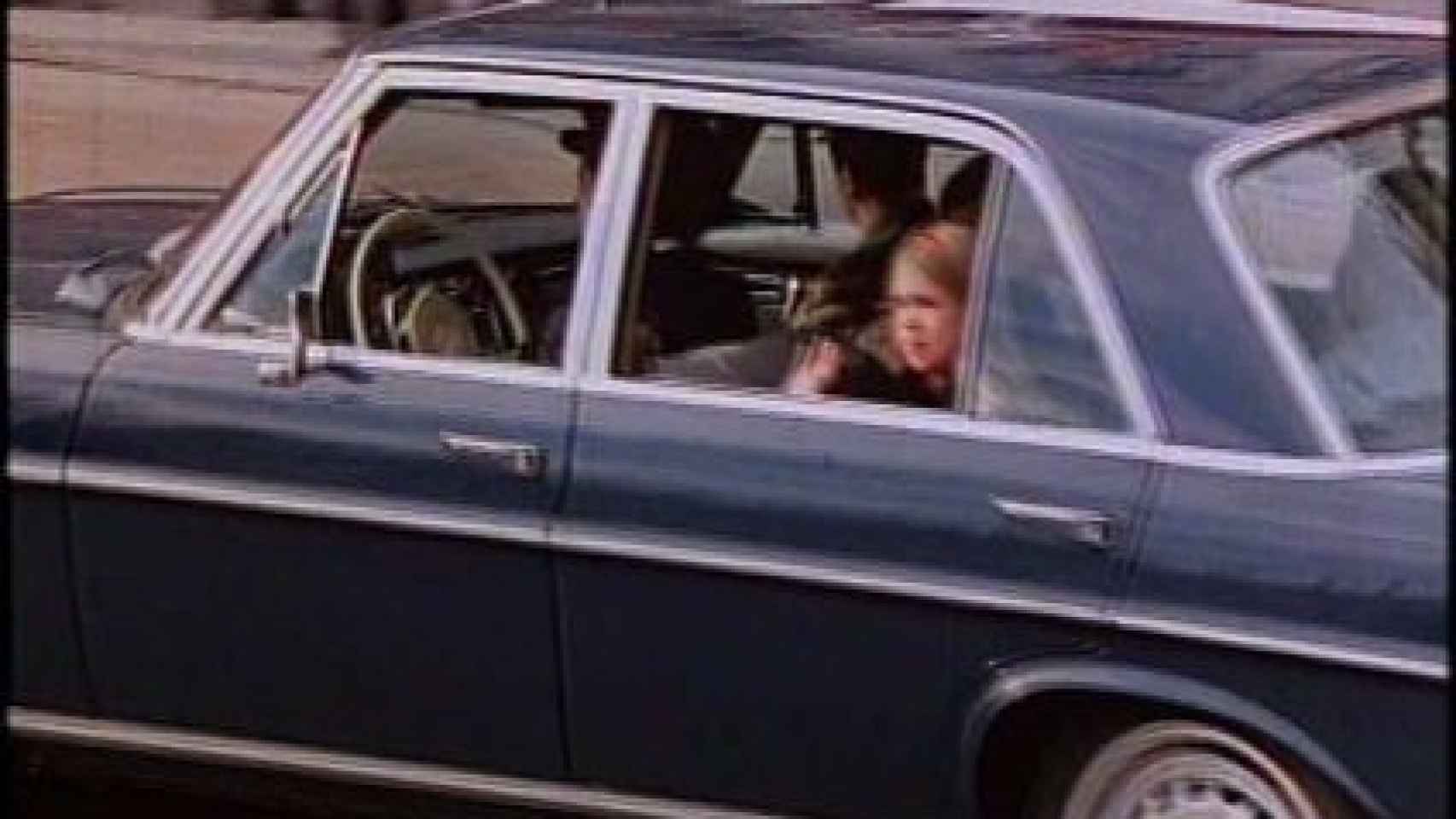 La infanta Cristina saluda desde el asiento trasero del coche Mercedes Benz 300 SEL.