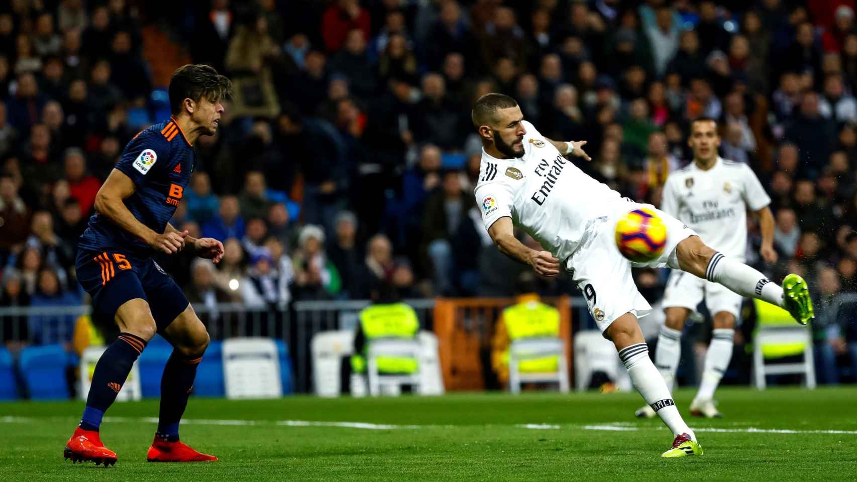 Karim Benzema golpea el balón ante el defensa brasileño del Valencia, Gabriel Paulista