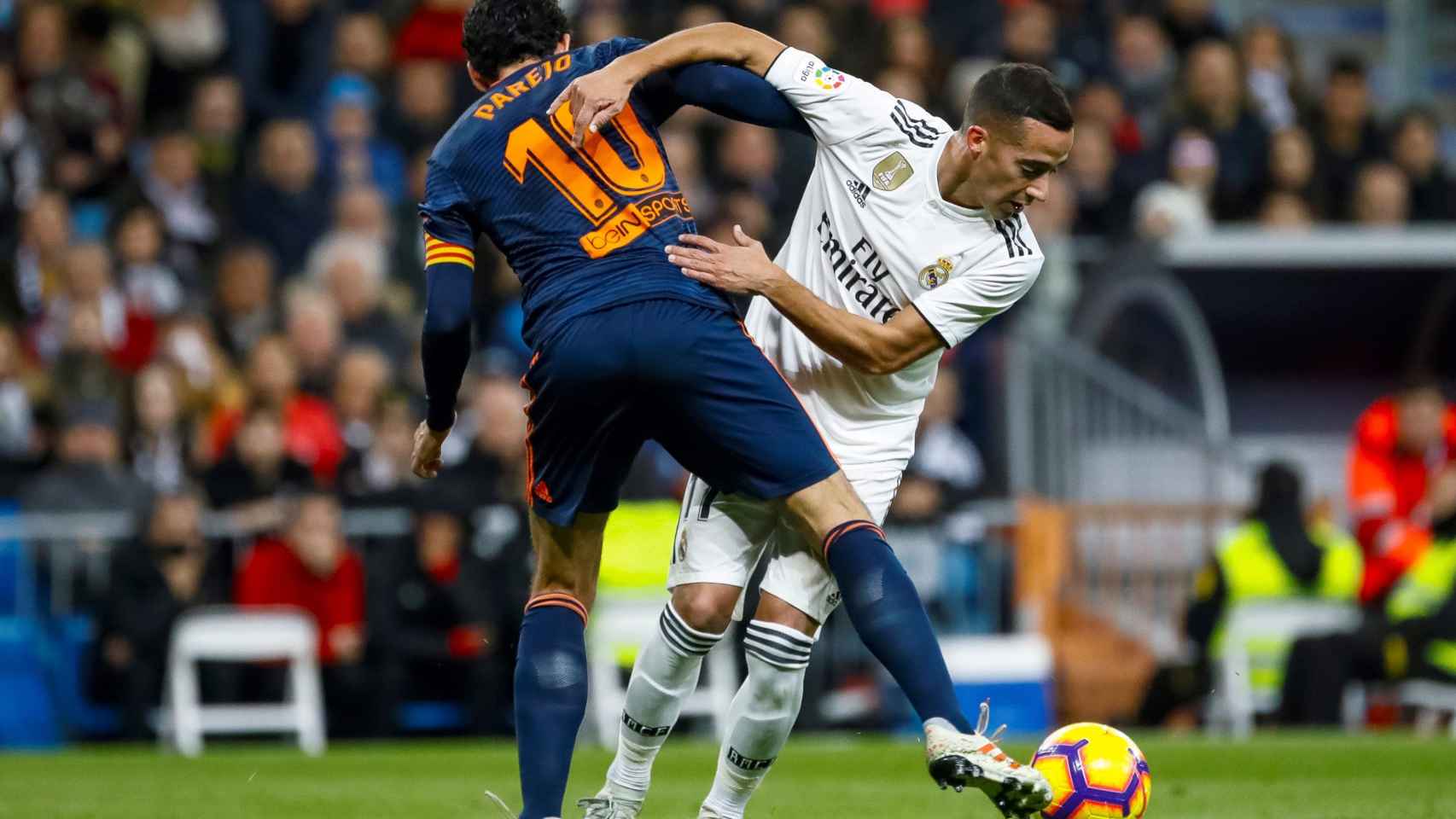 Lucas Vázquez lucha por el balón frente al centrocampista del Valencia, Dani Parejo