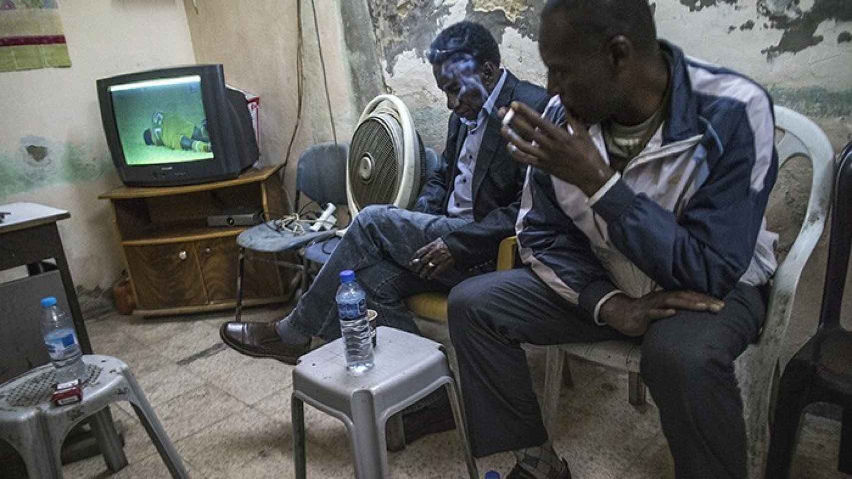 Dos aficionados siguen el partido del Markaz Tulkarem por televisión