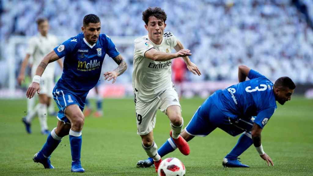 Juan Ramón Ruan y Jilmar Torres intentan arrebatar el balón al defensa del Real Madrid Alvaro Odriozola