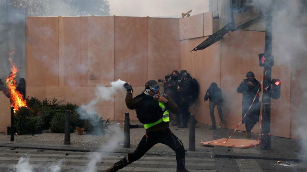 Un manifestante arroja un artefacto a los gendarmes.
