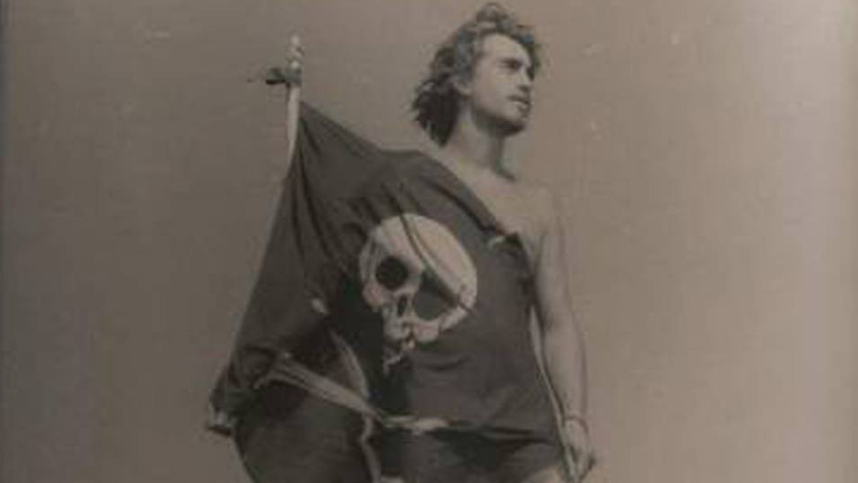 Una fotografía antigua de Germán con la bandera pirata a la puerta de su casa.