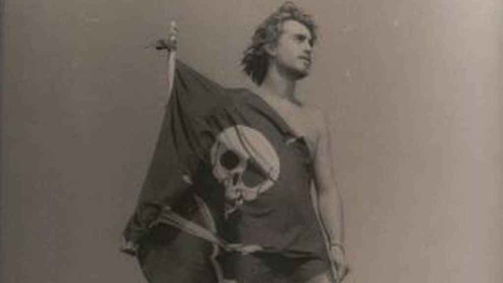 Una fotografía antigua de Germán con la bandera pirata a la puerta de su casa.