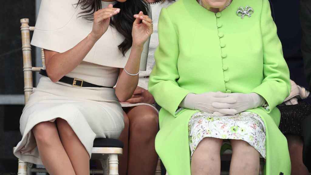 La reina de Inglaterra, Meghan Markle y Samantha Cohen, entre las dos.