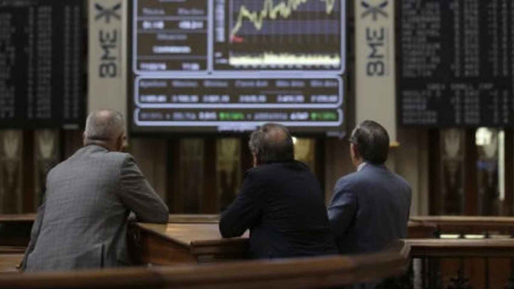 Varios inversores contemplan pantallas de negociación en la Bolsa de Madrid.